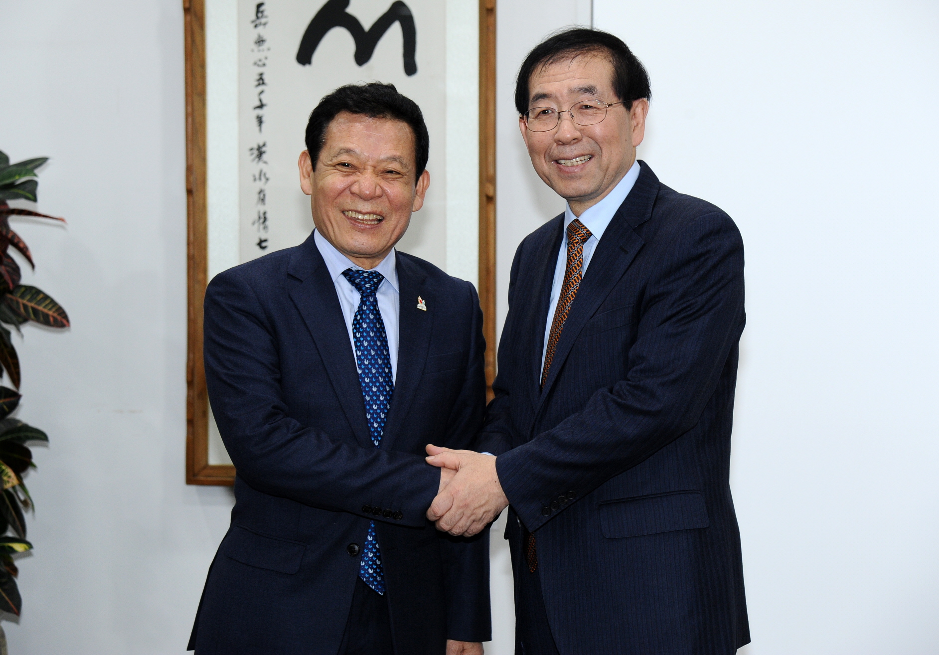 윤장현 광주시장과 박원순 서울시장이 손을 잡고 활짝 웃고 있다.